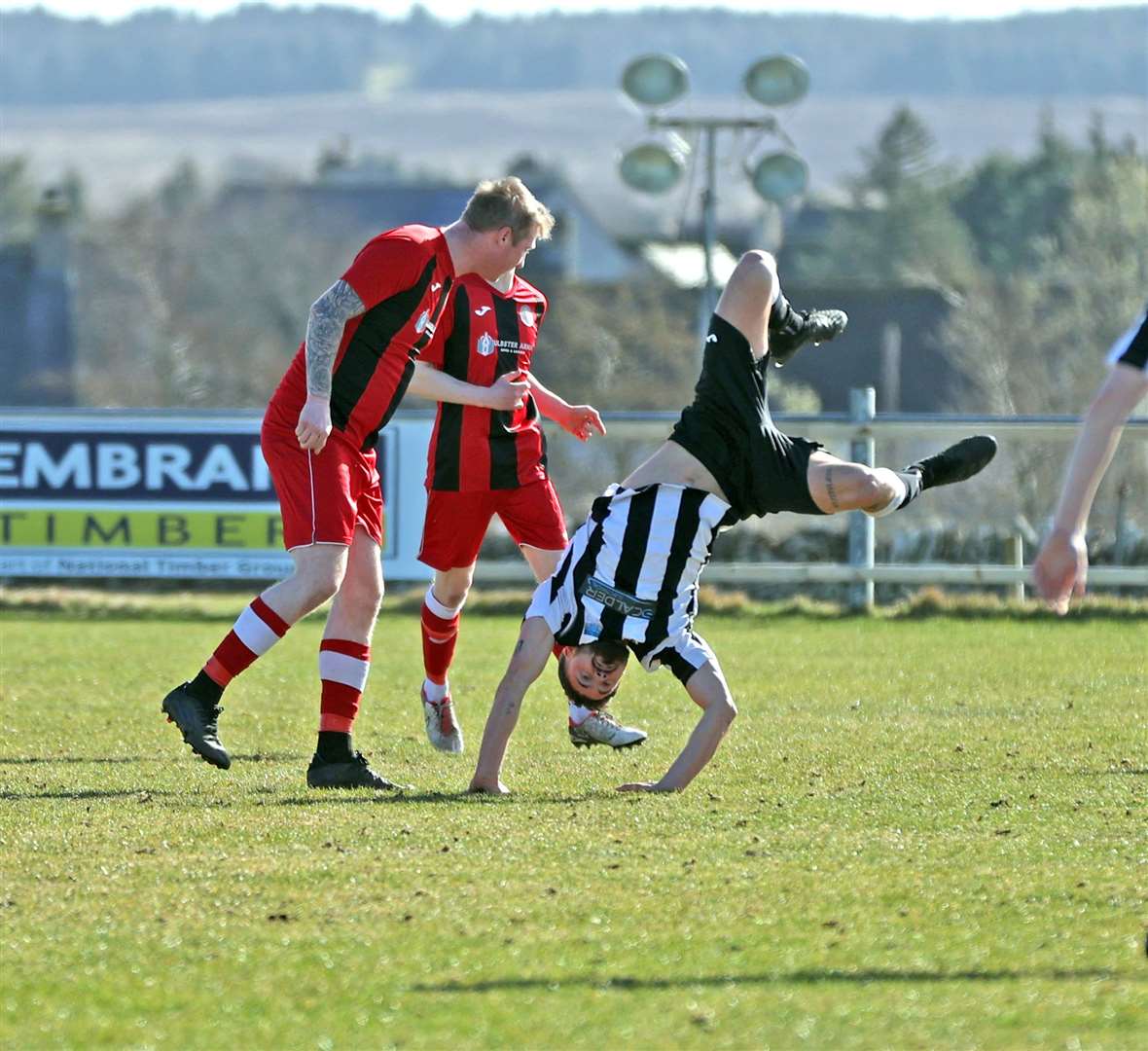 Alness United's Joel Burnett takes a tumble after clashing with Halkirk United defender Aidan Reid. Picture: James Gunn