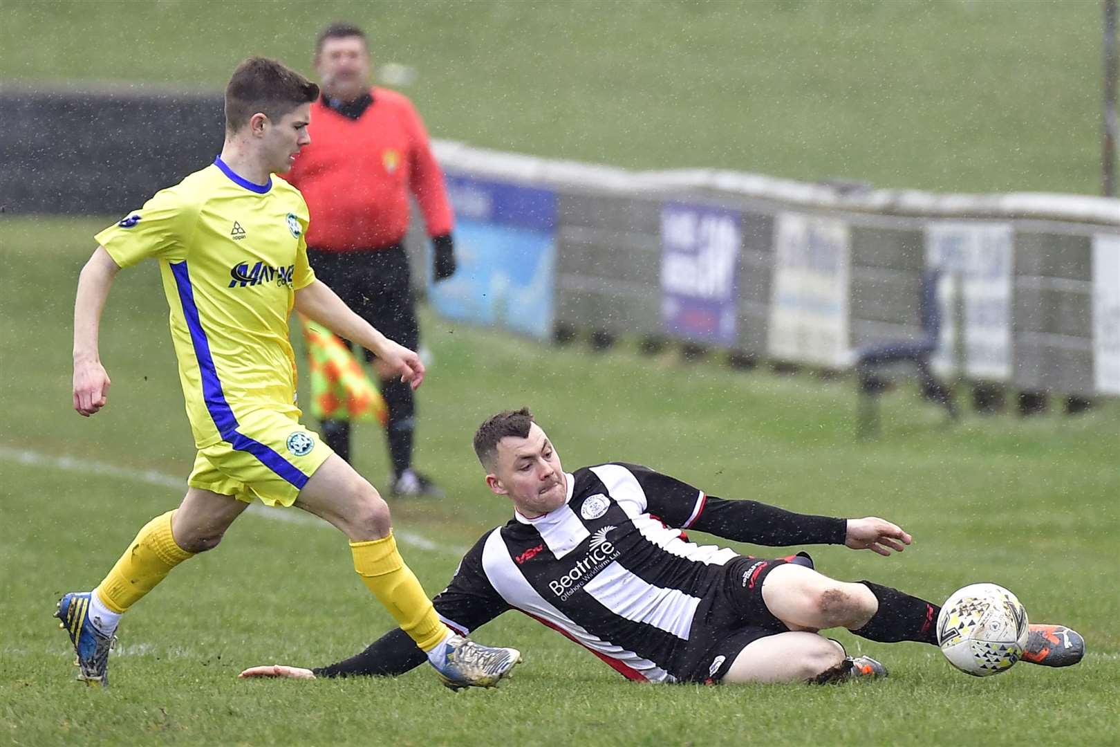 Wick Academy's Ryan Campbell slides in to beat Buckie's Marcus Goodall to the ball. Picture: Mel Roger
