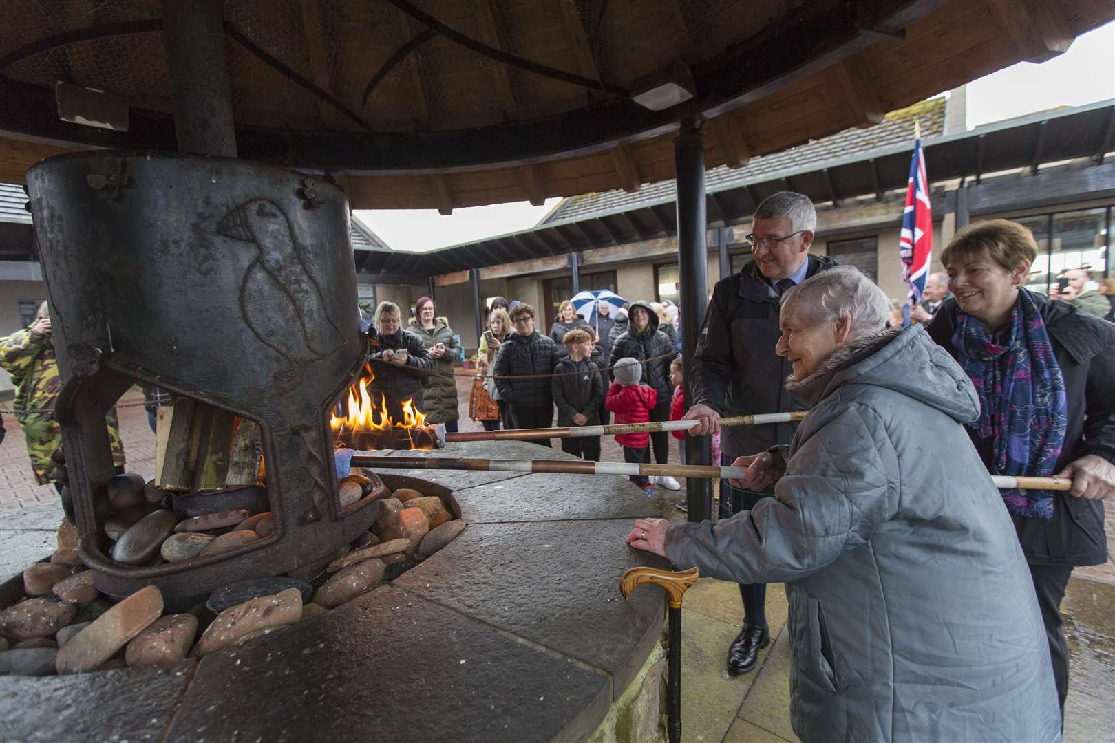 Nellie Manson, assisted by her daughter Fiona Harper, along with Vice-Lieutenant Willie Watt lighting the beacon at the John O'Groats forge. Picture: Robert MacDonald / Northern Studios