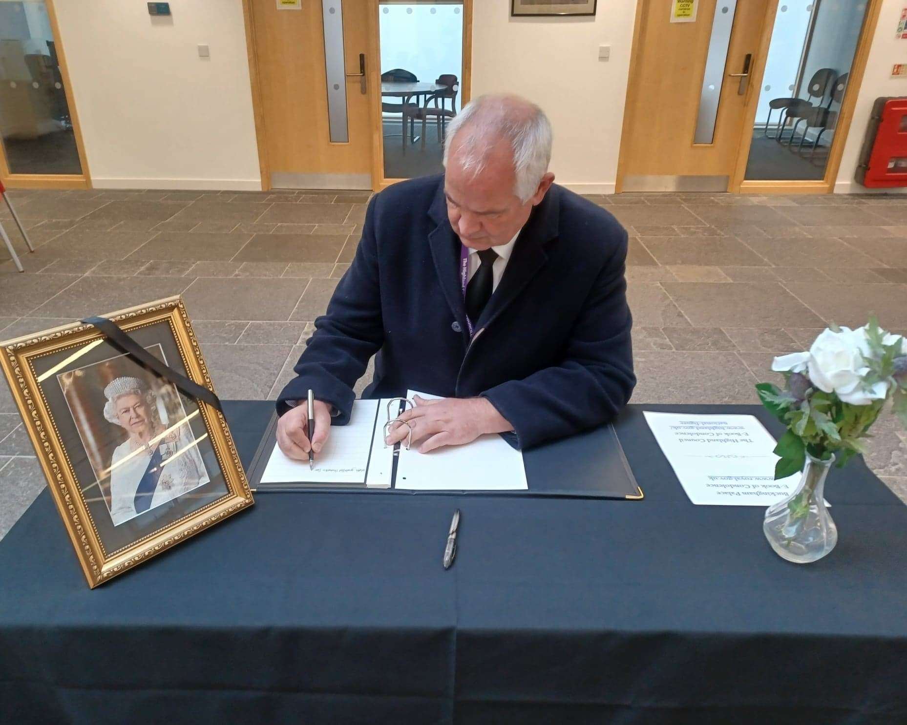 Highland Council leader Raymond Bremner signing the book of condolence at Wick.