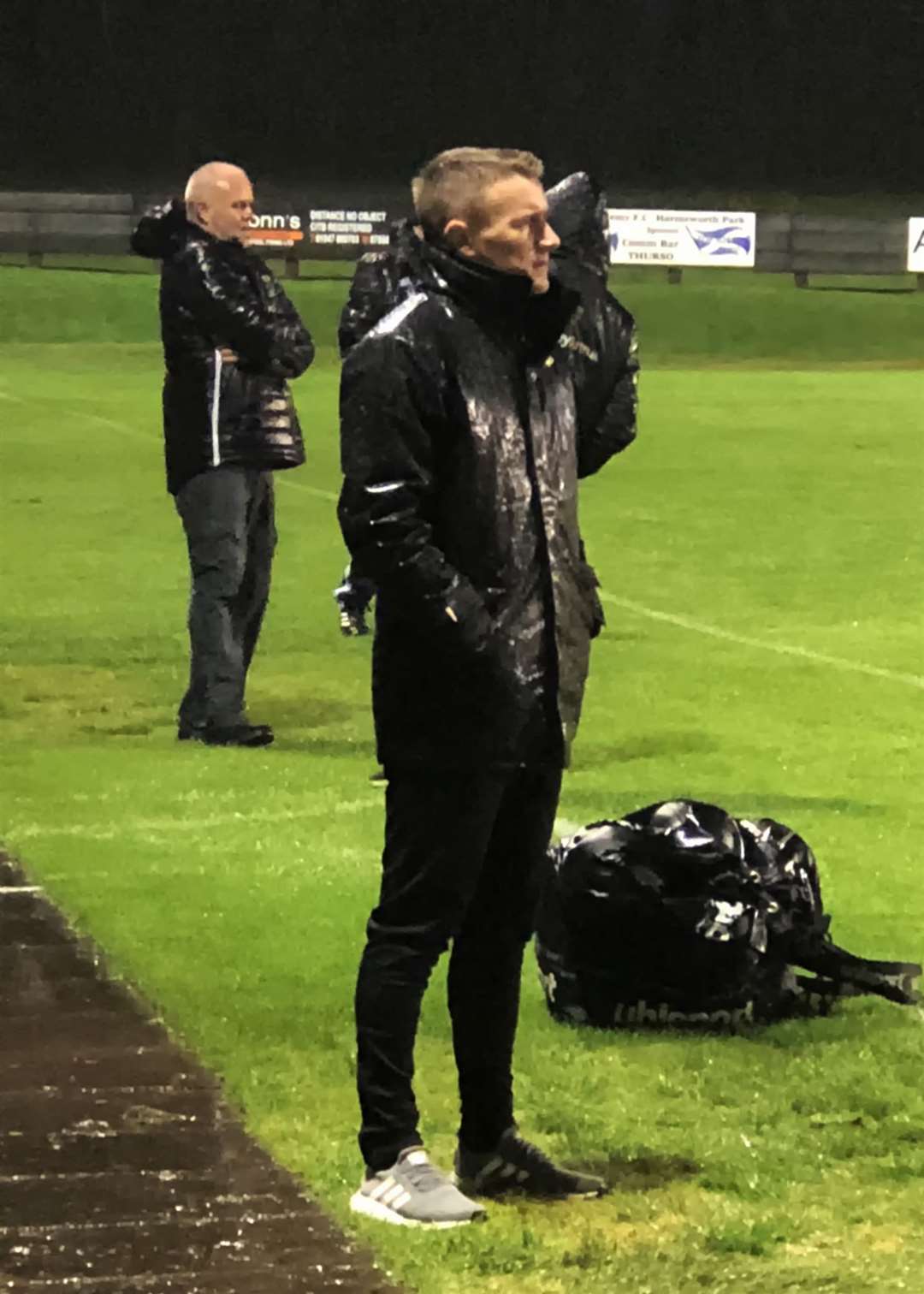 Wick Academy manager Gary Manson at a wet Harmsworth Park, with Thurso boss Stevie Reid beyond.