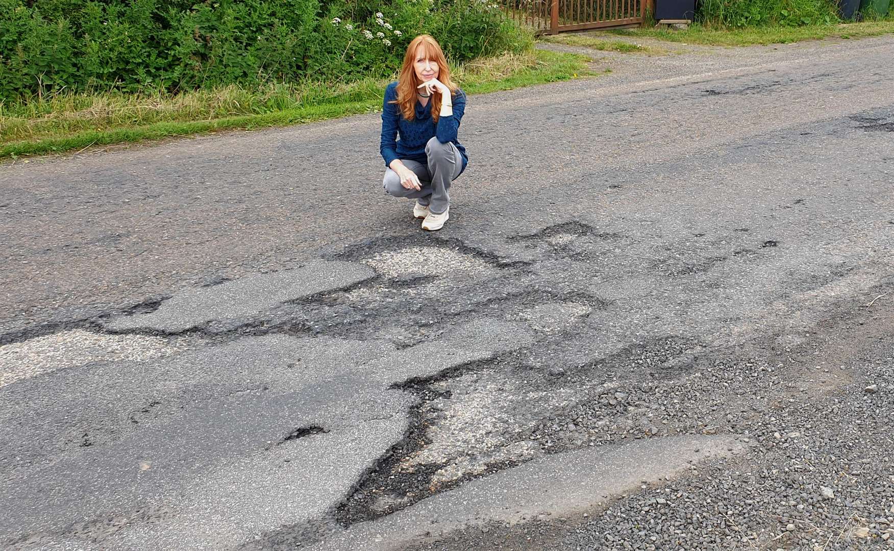 Helen Campbell of Caithness Roads Recovery beside a damaged section of road near Halkirk.