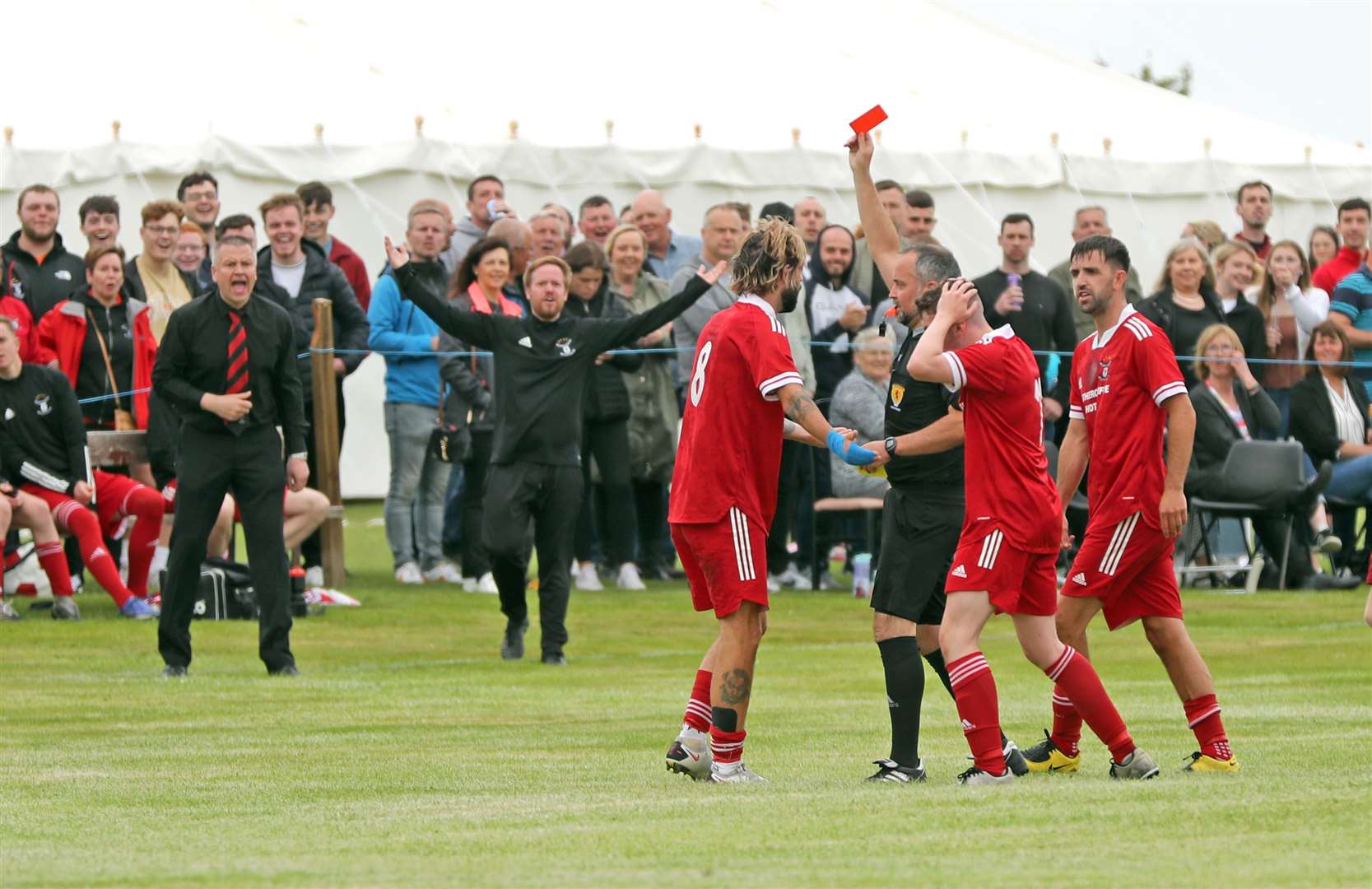 Referee Liam Bremner shows the red card to Grant MacNab of Wick Groats as manager Kevin Anderson protests. Picture: James Gunn