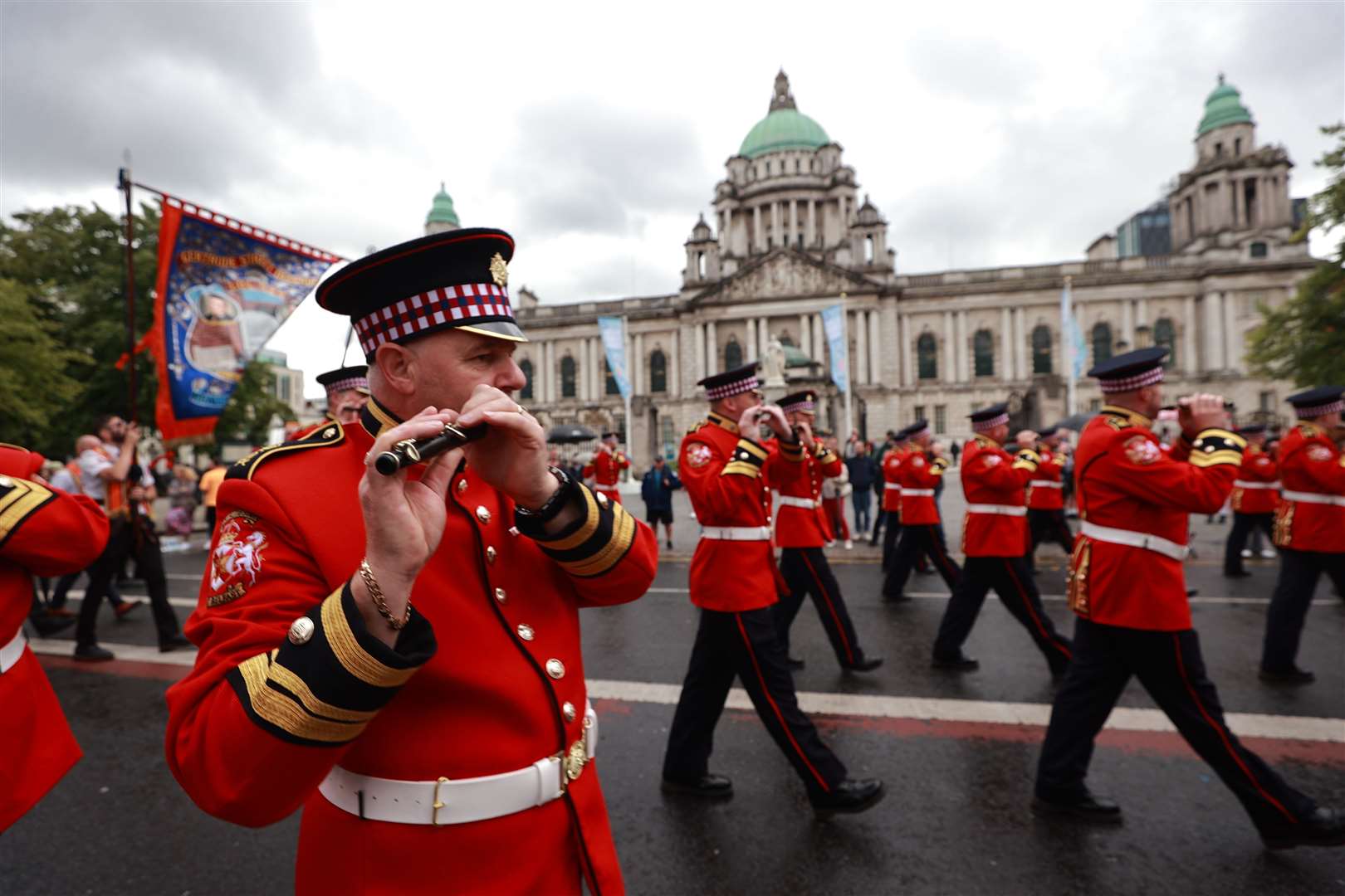 Members of a flute band pass Belfast City Hall as they take part in a Twelfth of July parade (Liam McBurney/PA)