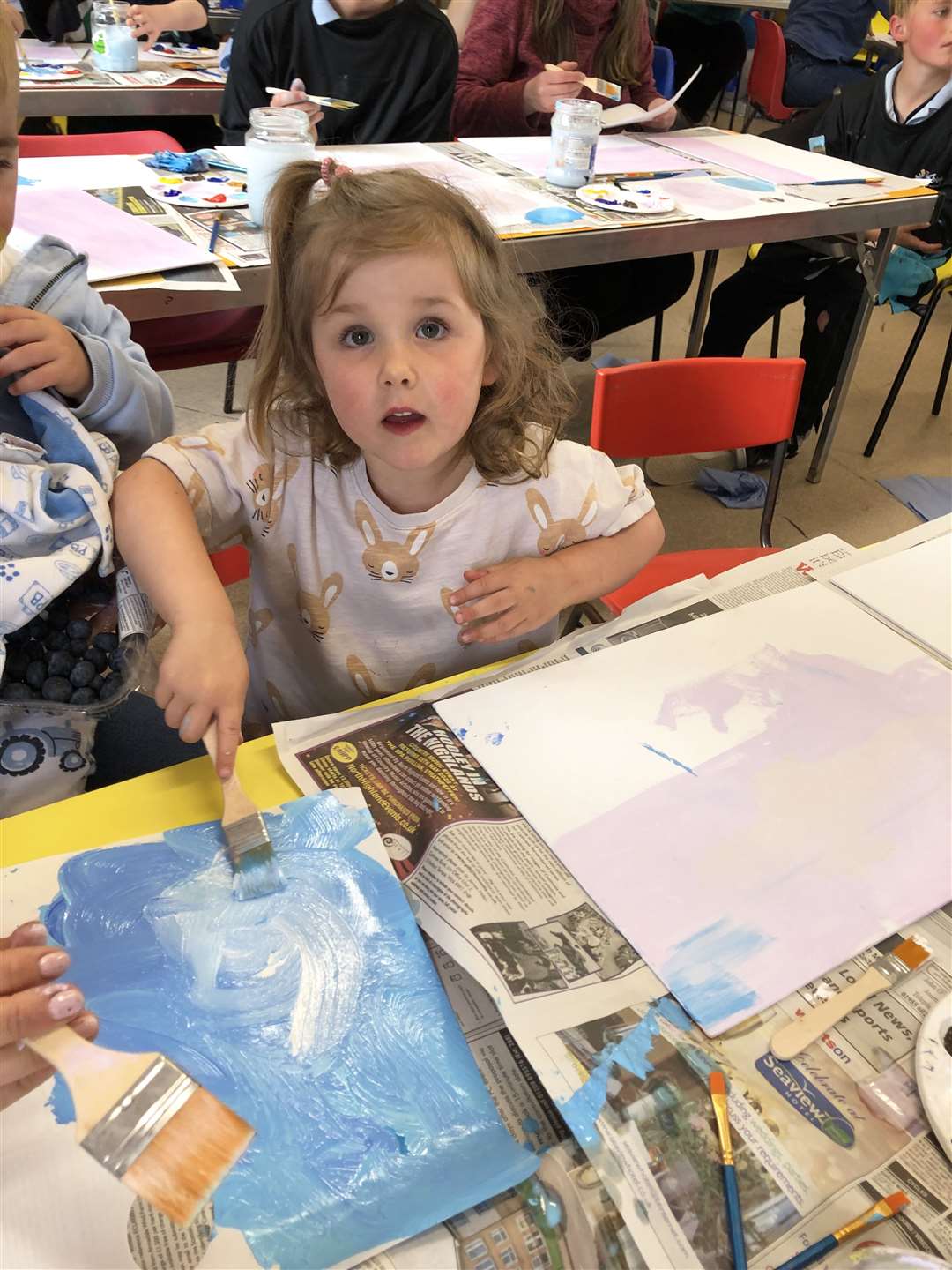 Nursery pupil Sofia mixing the colours for her canvas.