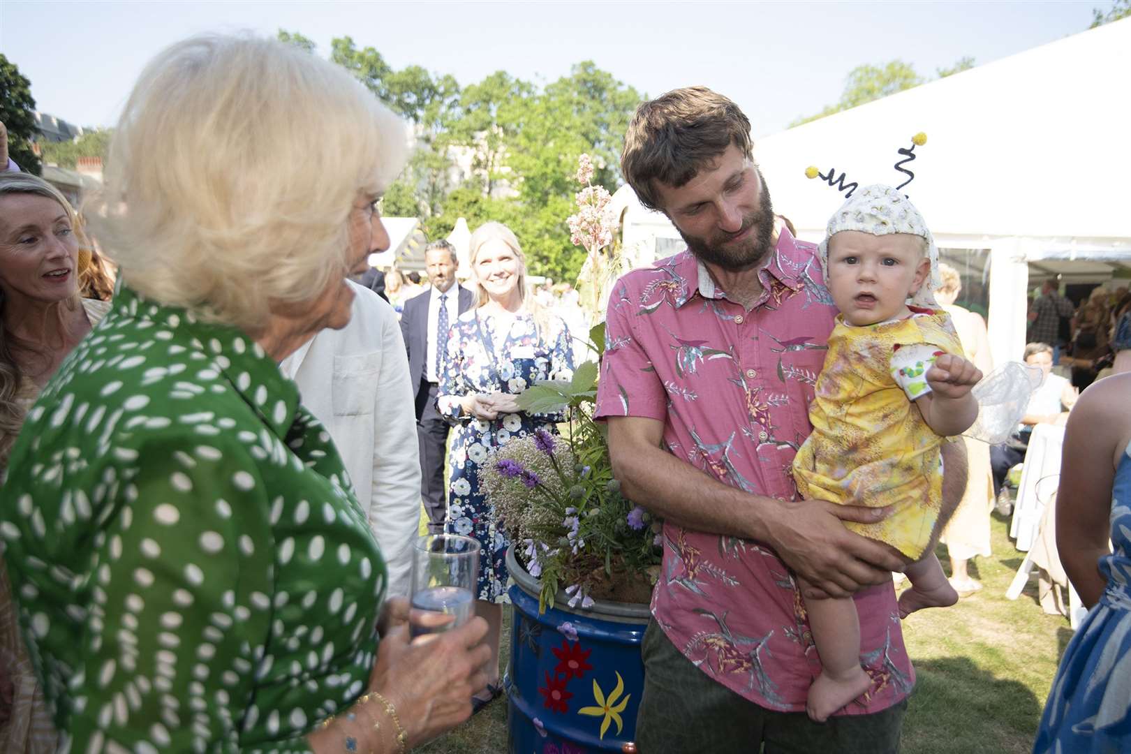 Camilla greeted nine-month-old Ota Rowan Zika who was sporting a bee costume (Eddie Mulholland/Daily Telegraph/PA)