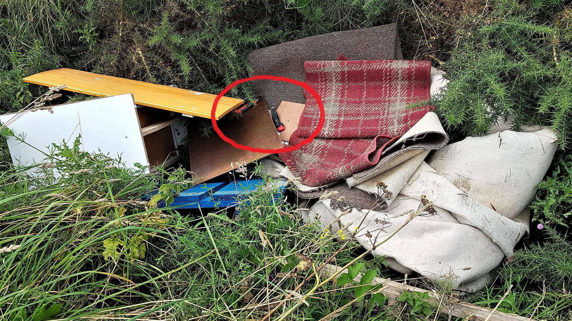 The circled area highlights two sharp knives in the pile of rubbish found near Thrumster. Picture: Willie Mackay