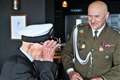Richard puts on the naval cap as Colonel Malec congratulates him.