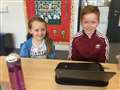 P6 pupil Joe Gill teaching P2 pupil Kara Simpson some French words using his Chromebook.