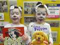 Two little primary one Dalmatians showing their books.