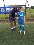 Marvin Andrews presents a pair of ArmourFlex shinguards to player of the camp (10 to 15 year olds) Kieran Dooner.