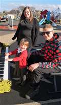 Emma Sewell with her daughter Lacey listen to James Tofalli play in the park.
