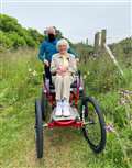 George gives Eileen Perry an opportunity to try the off-road wheelchair.
