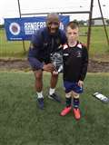 Marvin Andrews presents a pair of ArmourFlex shinguards to player of the camp (10 to 15 year olds) Jamie Steven.