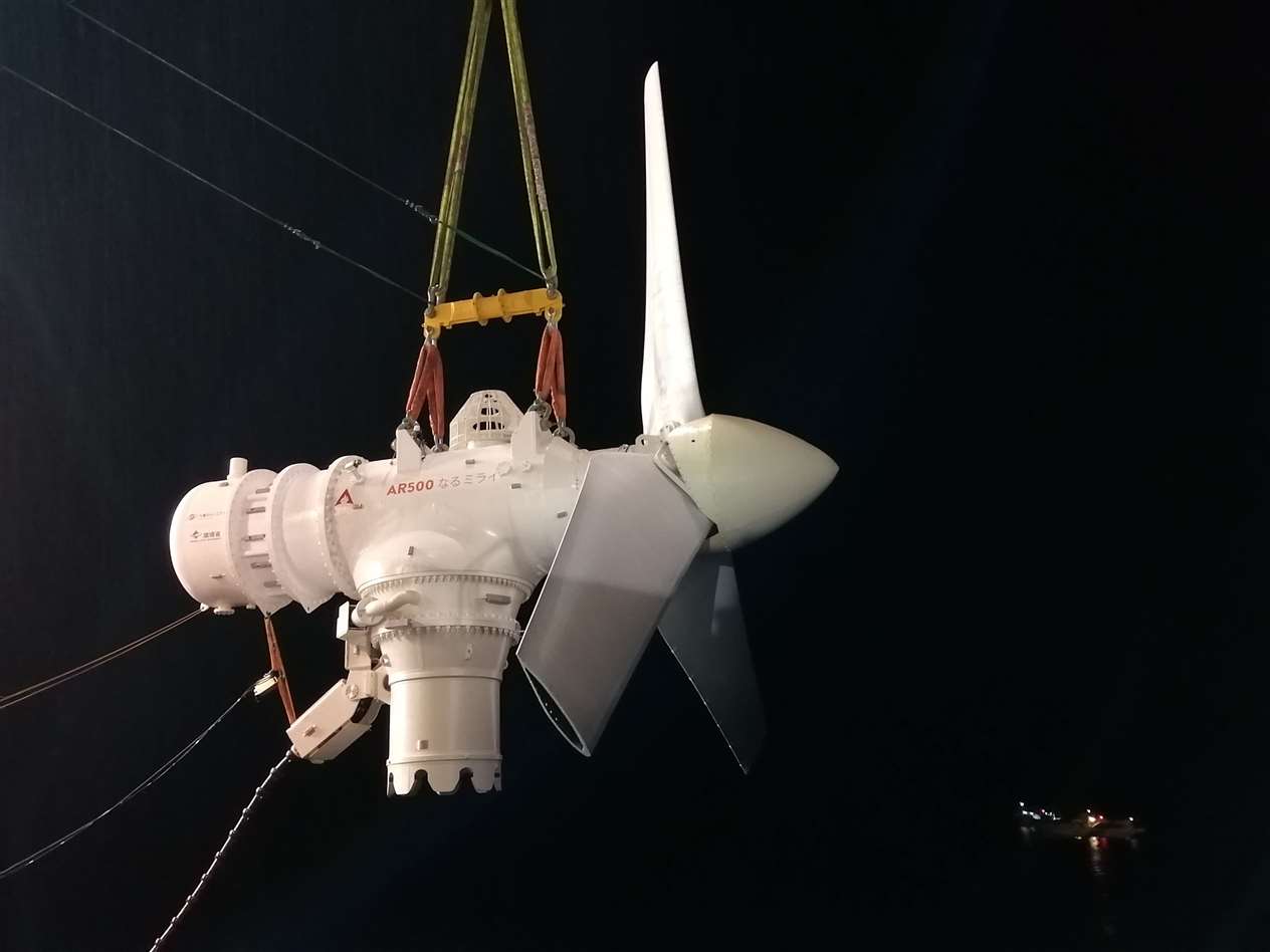 The turbine is hoisted into the air ahead of its installation.