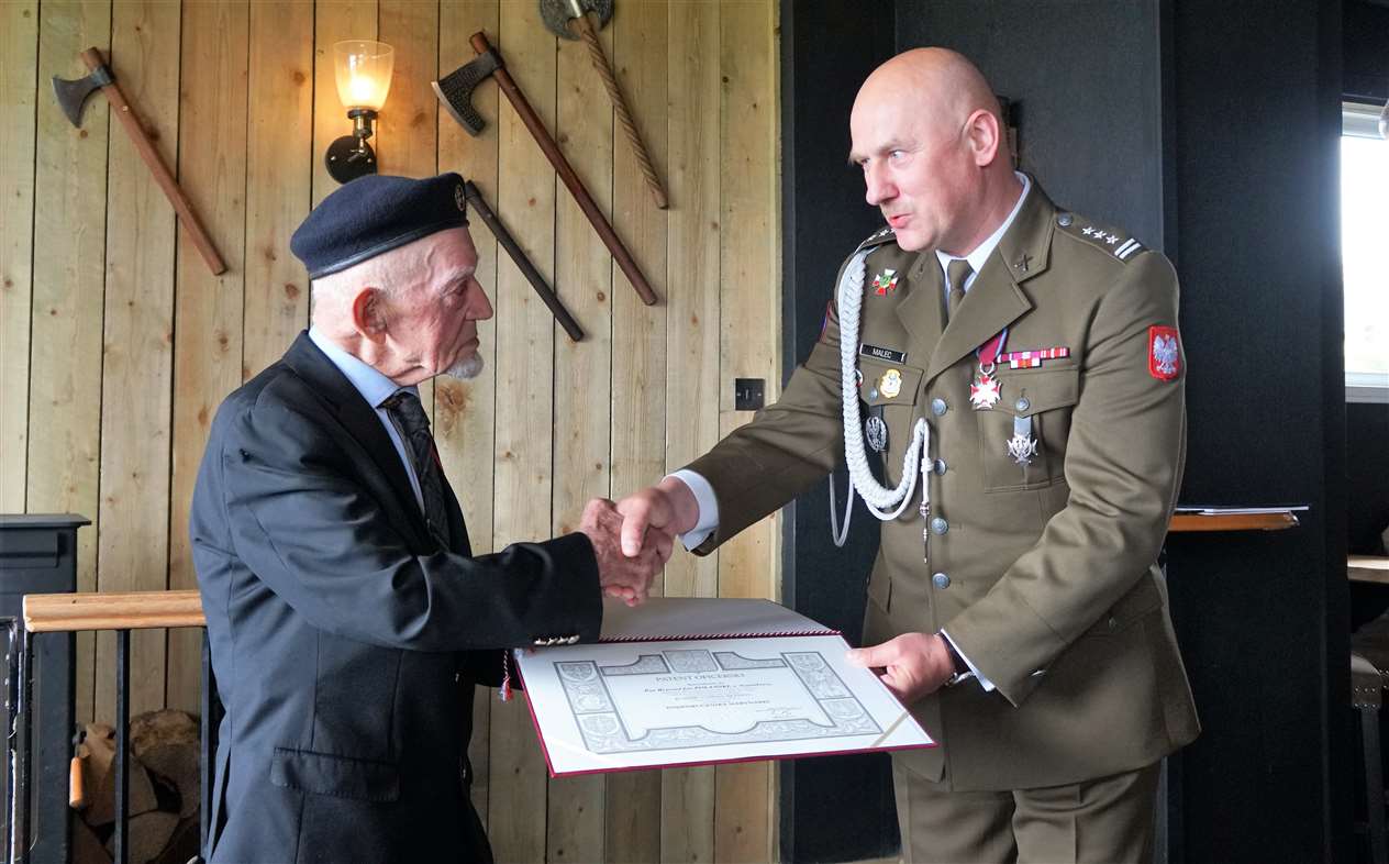 Richard Polanski, left, is congratulated by Colonel Malec from the Polish embassy.