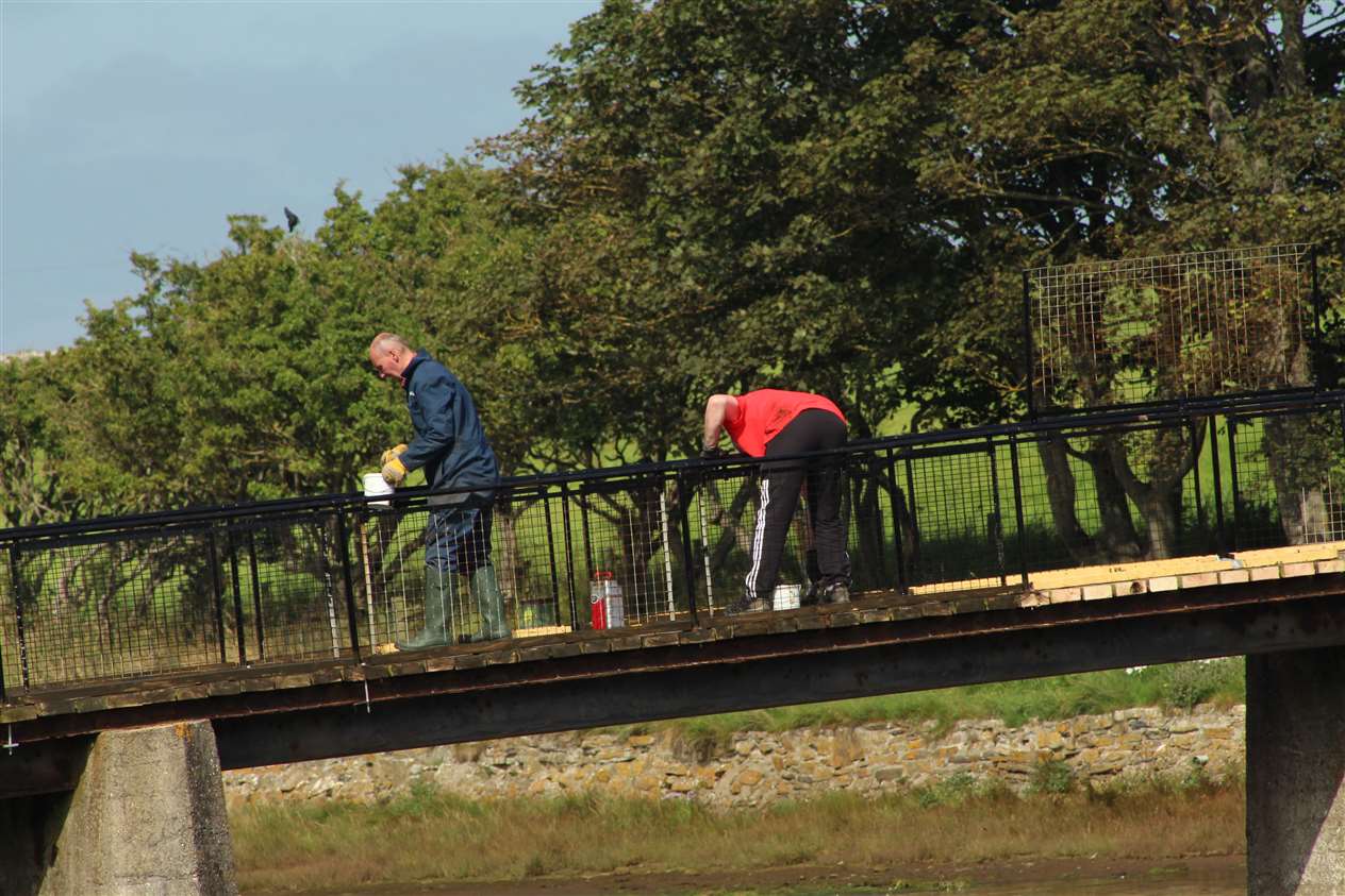 Two of the Wick Paths Group team painting railings on the main bridge.