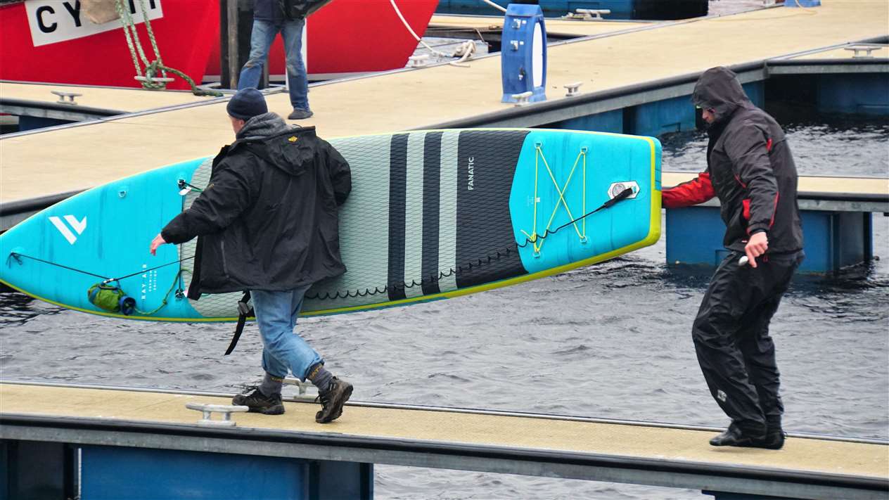 Phil Boardman helps Charlie with his paddleboard.