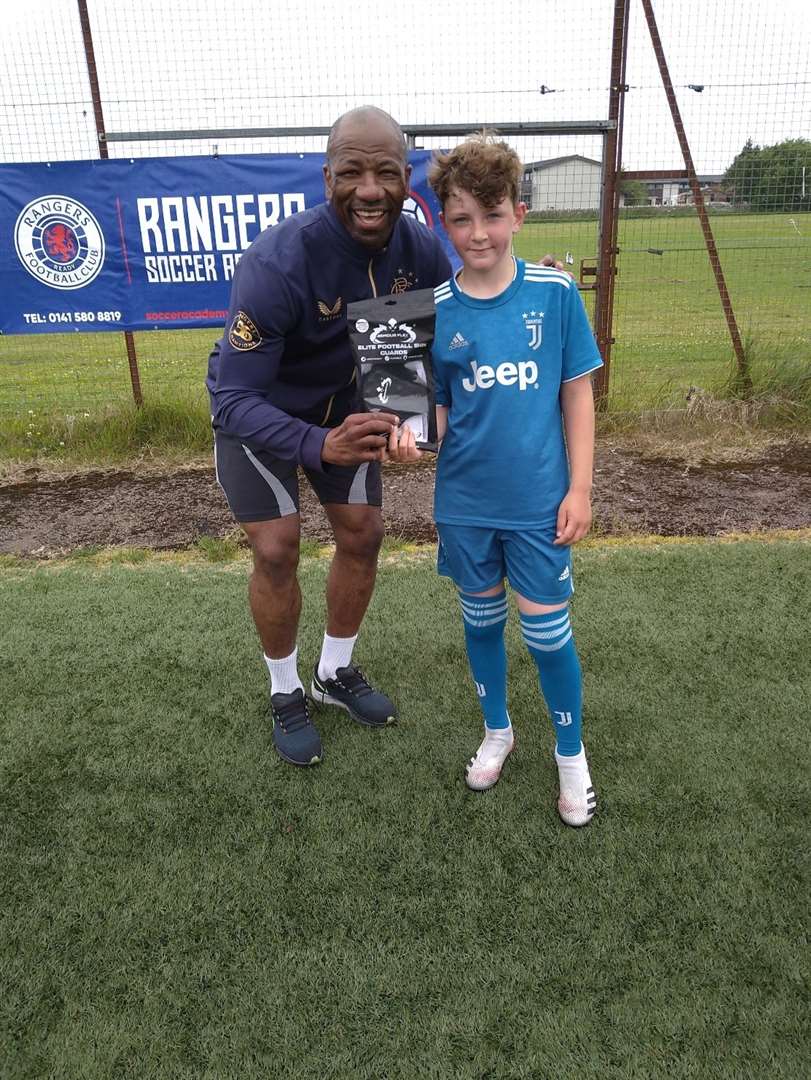 Marvin Andrews presents a pair of ArmourFlex shinguards to player of the camp (10 to 15 year olds) Kieran Dooner.
