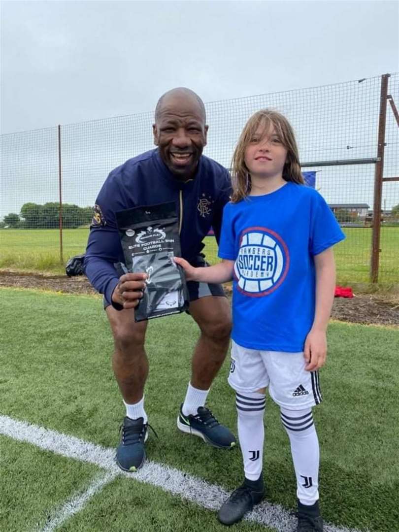 Marvin Andrews presents a pair of ArmourFlex shinguards to player of the camp (five to nine year olds) Ella Mackenzie.