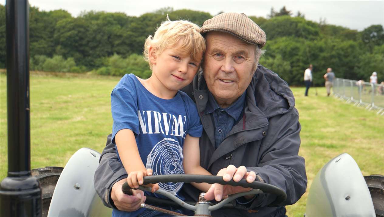 Peter Stewart from Thrumster, right, sits on a vintage tractor with his grandson Camden Hollick.