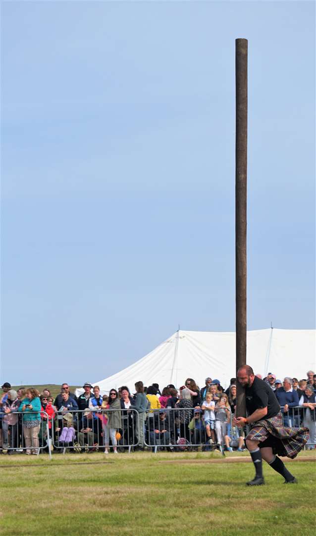 Another athlete, Stewart Anderson, takes part in the caber toss. Picture: DGS