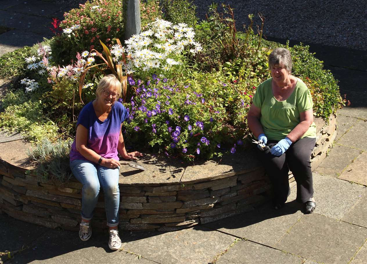 Volunteers Yvonne Hendry (left) and Catherine Miller working in the memorial garden earlier this month.