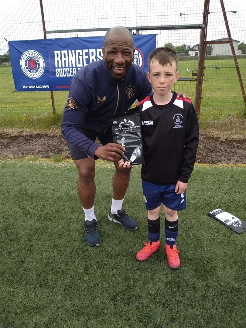 Marvin Andrews presents a pair of ArmourFlex shinguards to player of the camp (10 to 15 year olds) Jamie Steven.