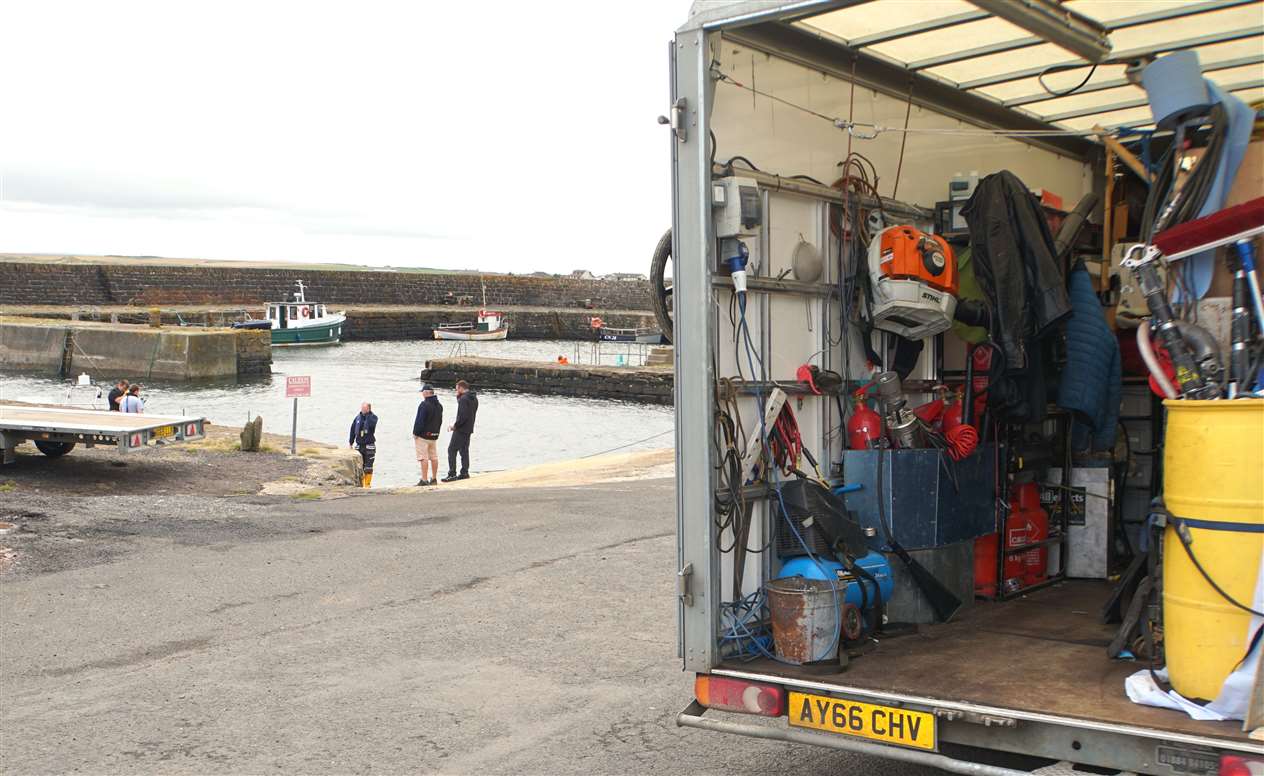 The crew prepare special effects for the shoot while a production facilities van sits in the foreground.