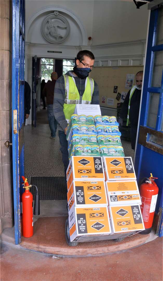 The goods are unloaded and taken in through the doors of the food bank.