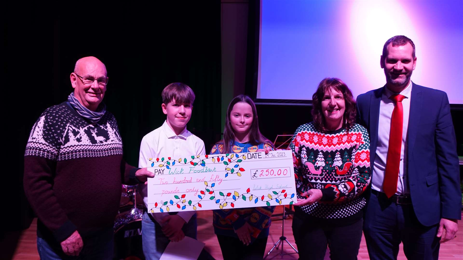 Pat and Grant Ramsay from Caithness Foodbank's Wick branch receiving a cheque of donated proceeds from last year’s concert ticket sales from Andrew Sinclair, Lucy Thain and rector, Sebastian Sandecki. Picture: DGS