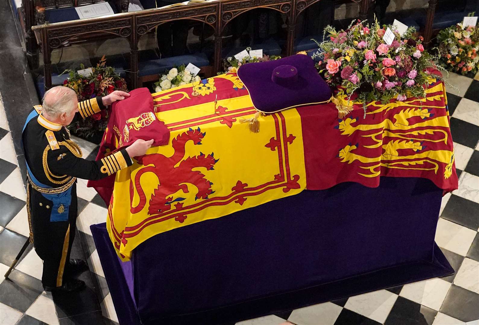 The King places the the Queen’s Company Camp Colour of the Grenadier Guards on the coffin at the Committal Service for Queen Elizabeth II, held at St George’s Chapel in Windsor Castle (Jonathan Brady/PA)