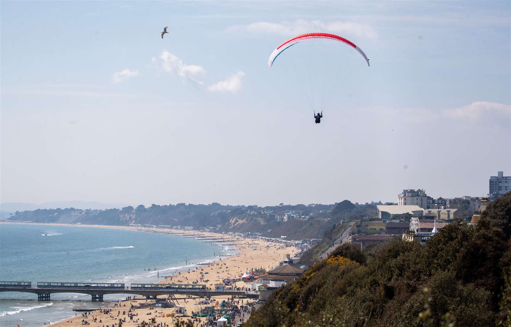 A person paraglides over the cliffs above Bournemouth beach (Andrew Matthews/PA)