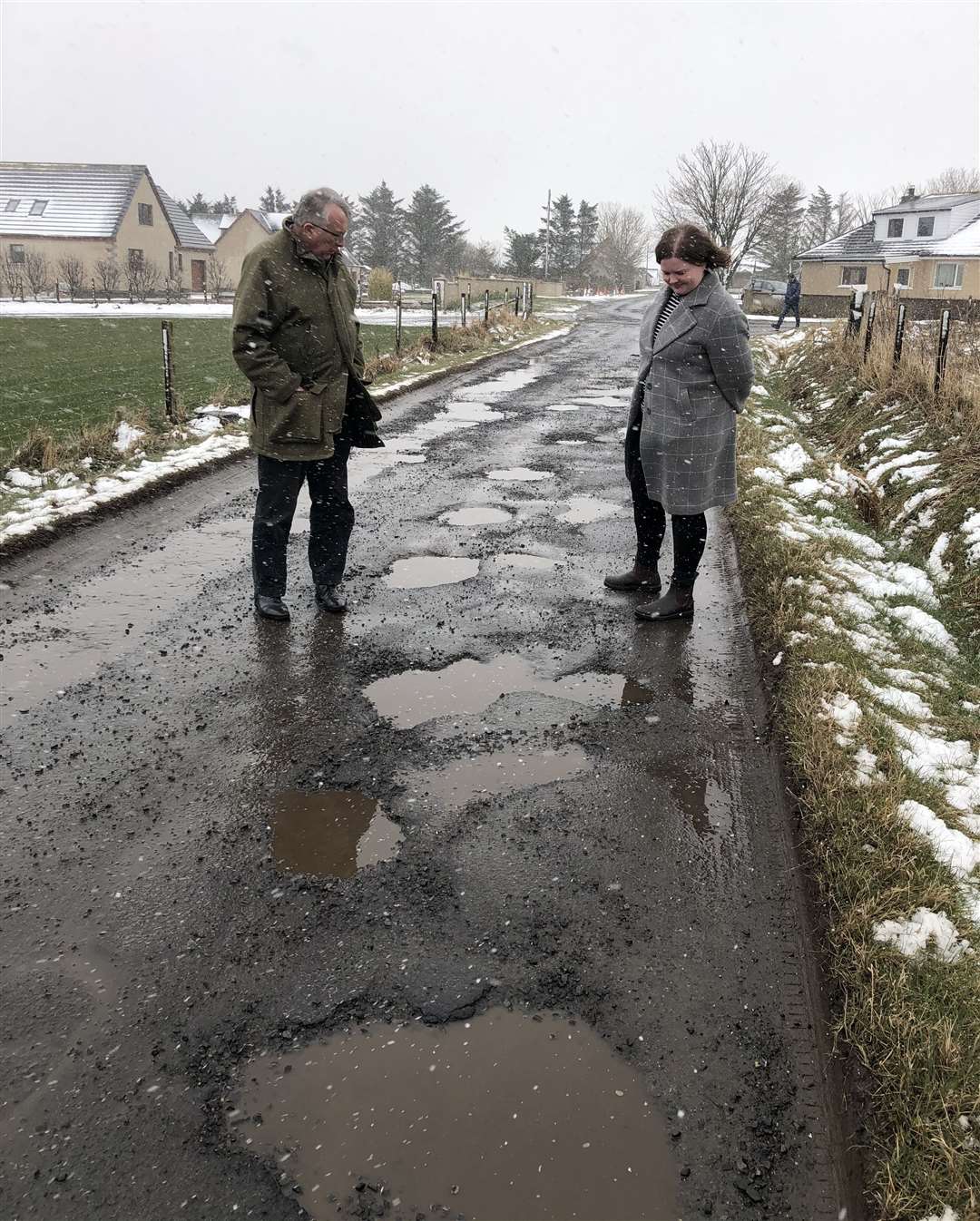 Jamie Stone and Molly Nolan examining a badly potholed road in Caithness.