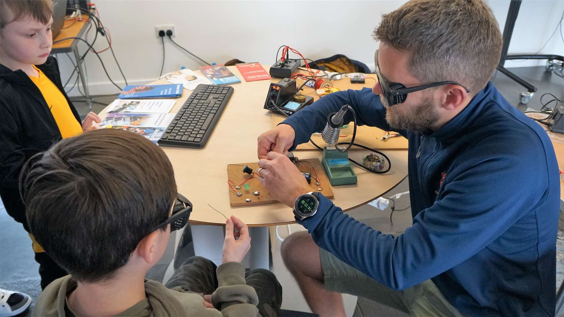 Science teacher Chris Aitken shows kids how to solder as part of the Caithness Amateur Radio Society stand. The children learned how to make a simple electrical circuit to turn on an LED light. Picture: DGS