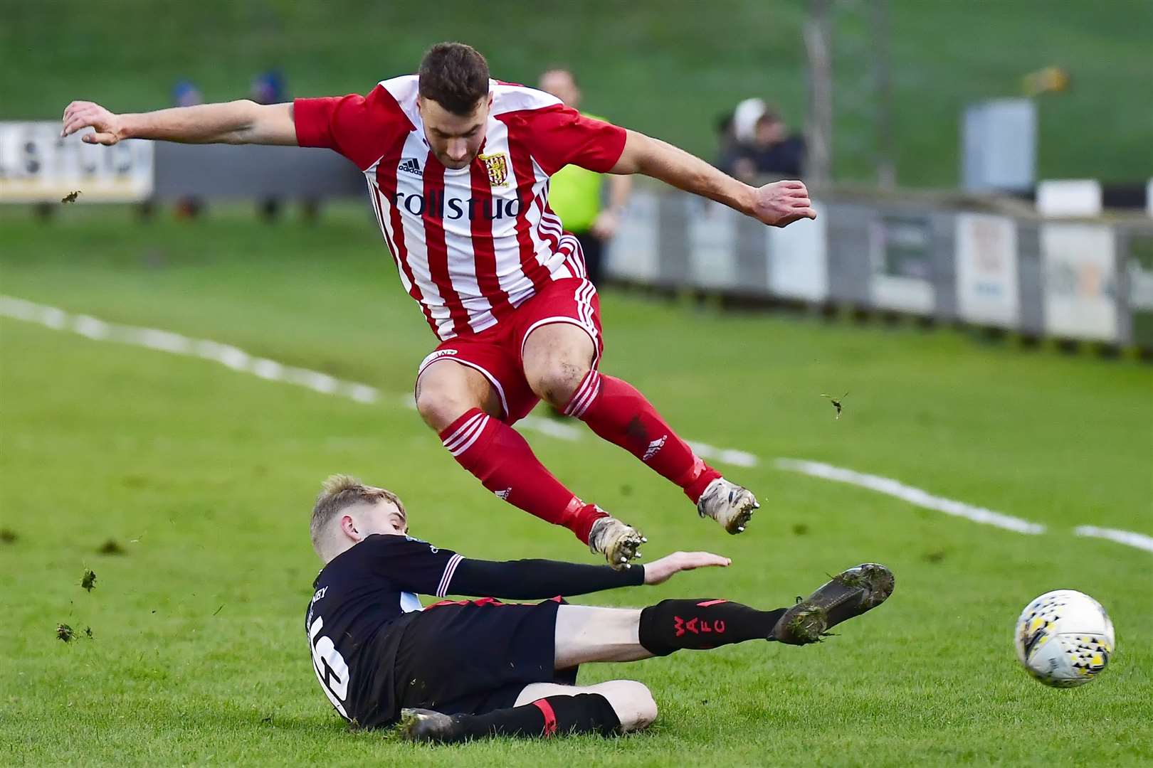 Formartine striker Scott Lisle leaps over a challenge by Wick Academy defender Joe Anderson during the Pitmedden side's 4-1 win at Harmsworth Park at the start of December. Picture: Mel Roger