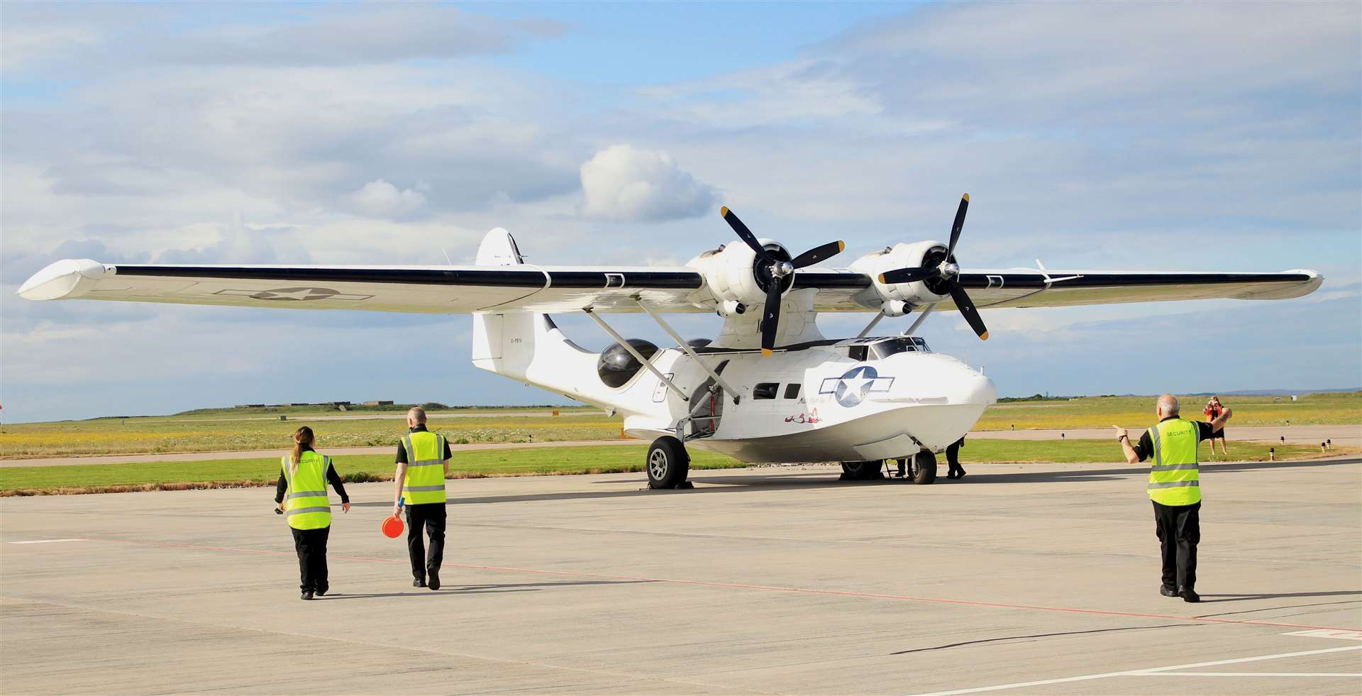 Airport staff making their way towards the Catalina after it landed in Wick. Picture: Alan Hendry