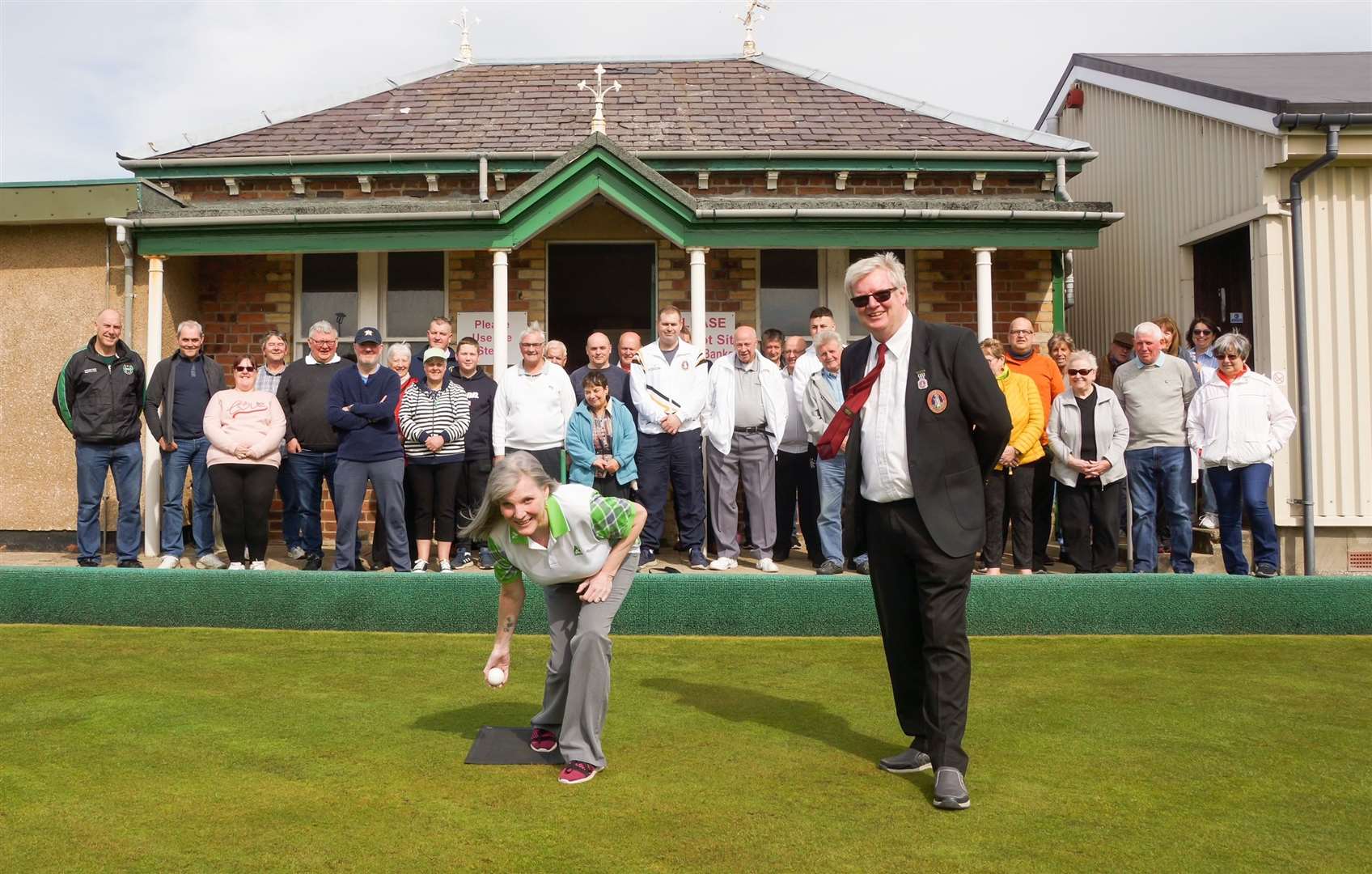 Lorna Cormack throwing the first jack of the season at Thurso, with president Douglas Morrison and club members looking on. Picture: Billy Husband