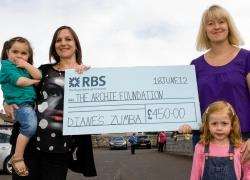 Diane Sinclair (left) and her two-year-old daughter Hannah hand over the £450 cheque for the ARCHIE Foundation to Jodie Henderson and her daughter Ellie. Photo: Robert MacDonald / Northern Studios.