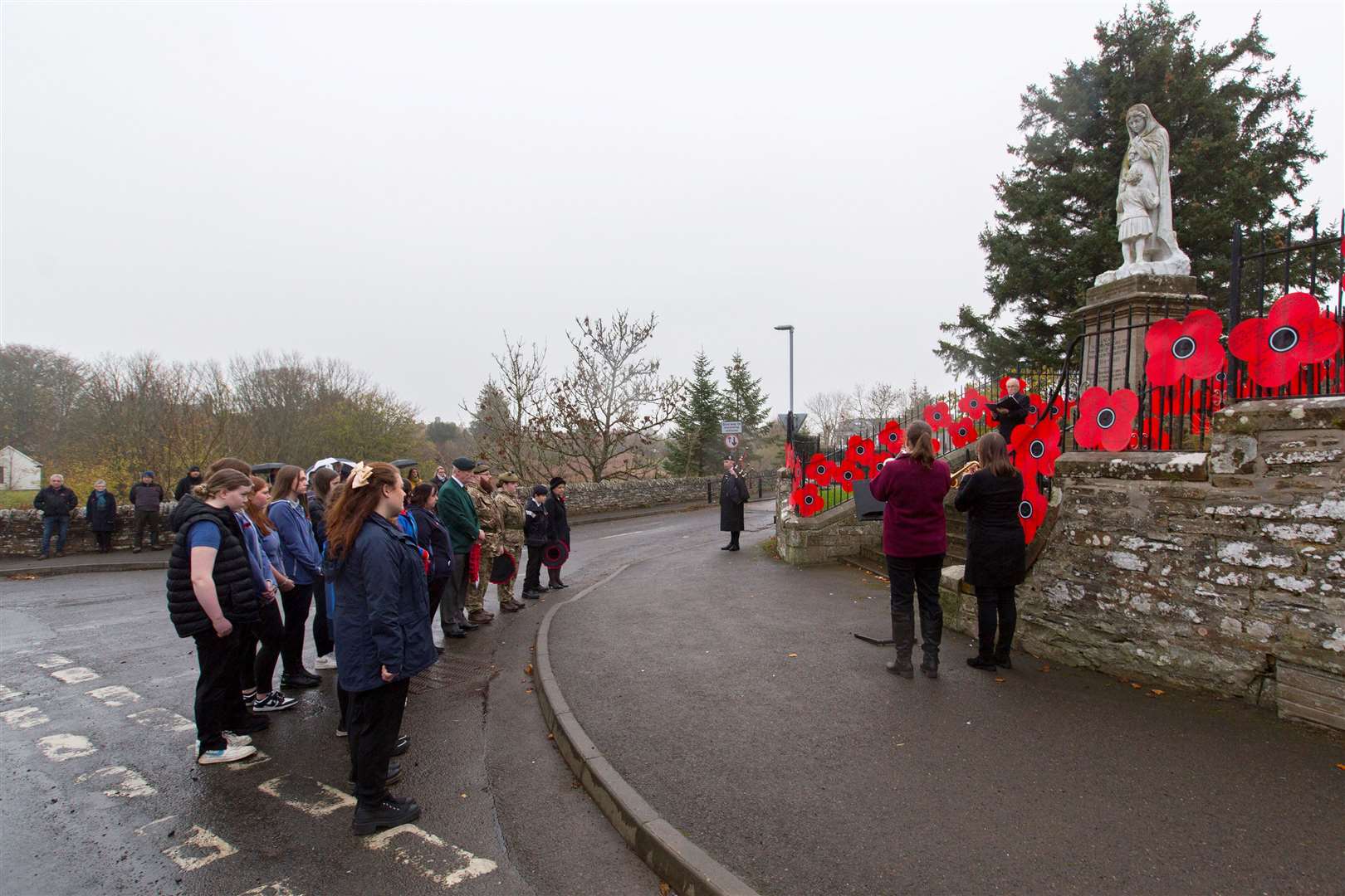 The scene at Halkirk war memorial on Remembrance Sunday morning as hardy souls gathered in the rain to lay poppy wreaths and remember the fallen. Picture: Robert MacDonald / Northern Studios