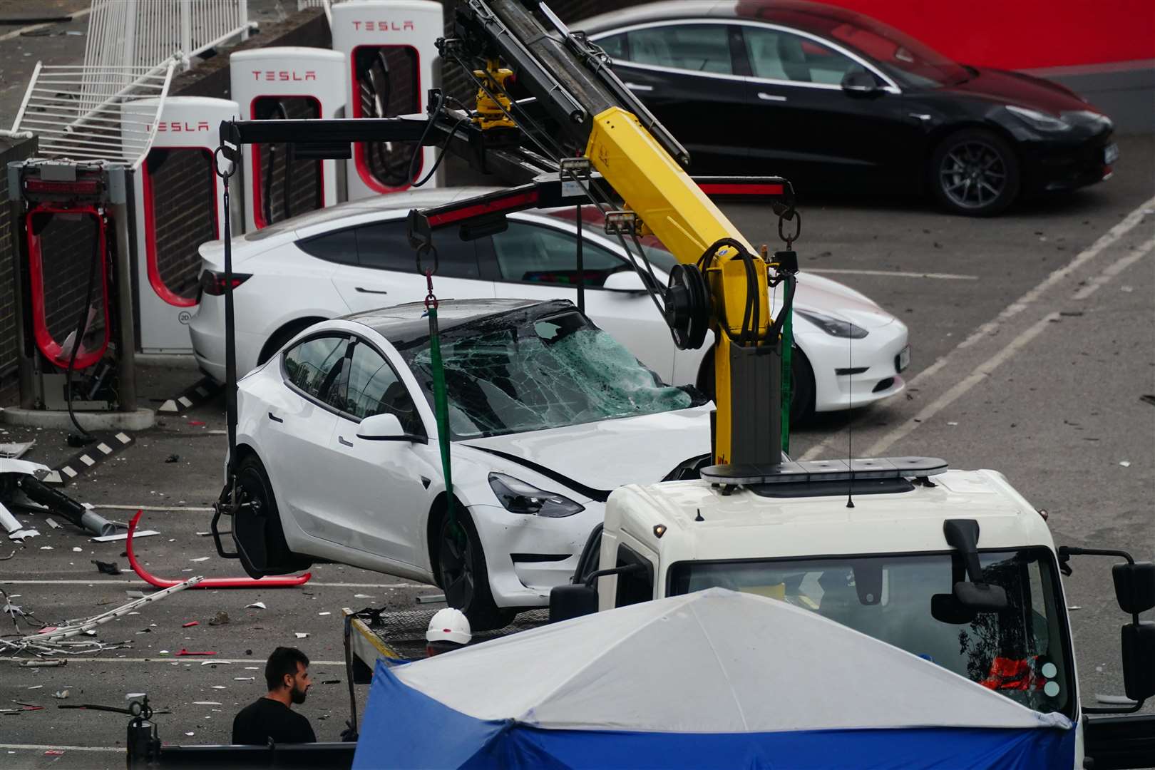 A damaged Tesla car is removed from the scene (Victoria Jones/PA)