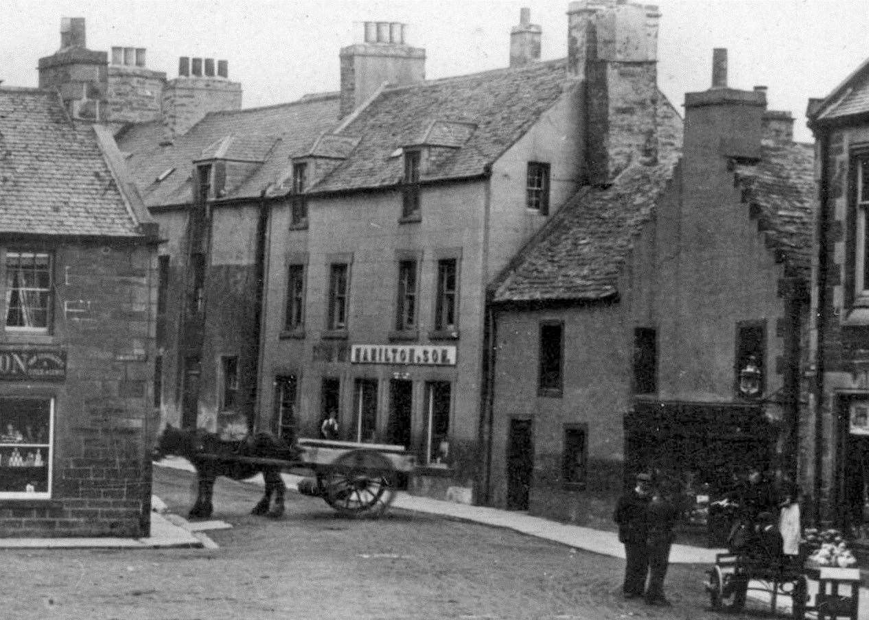 A view of High Street with a horse and cart parked across the road.
