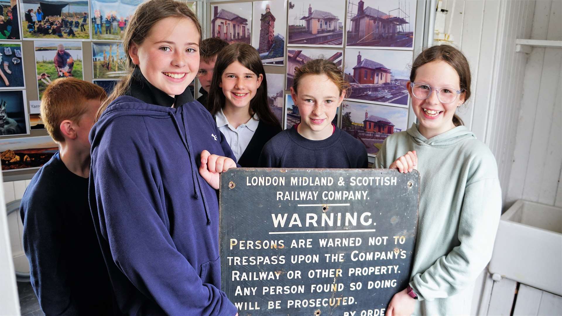 Thrumster Primary School kids hold up an old warning notice that stood by the line. Picture: DGS