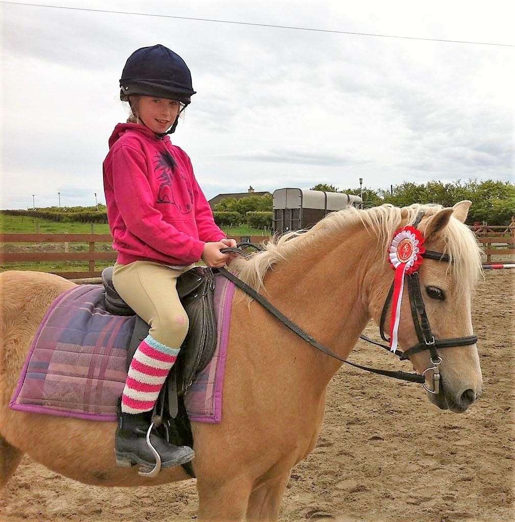 Megan at around eight-years-old sitting on her favourite Horsin' Around pony Princess Saffron. Picture: L Vuitton