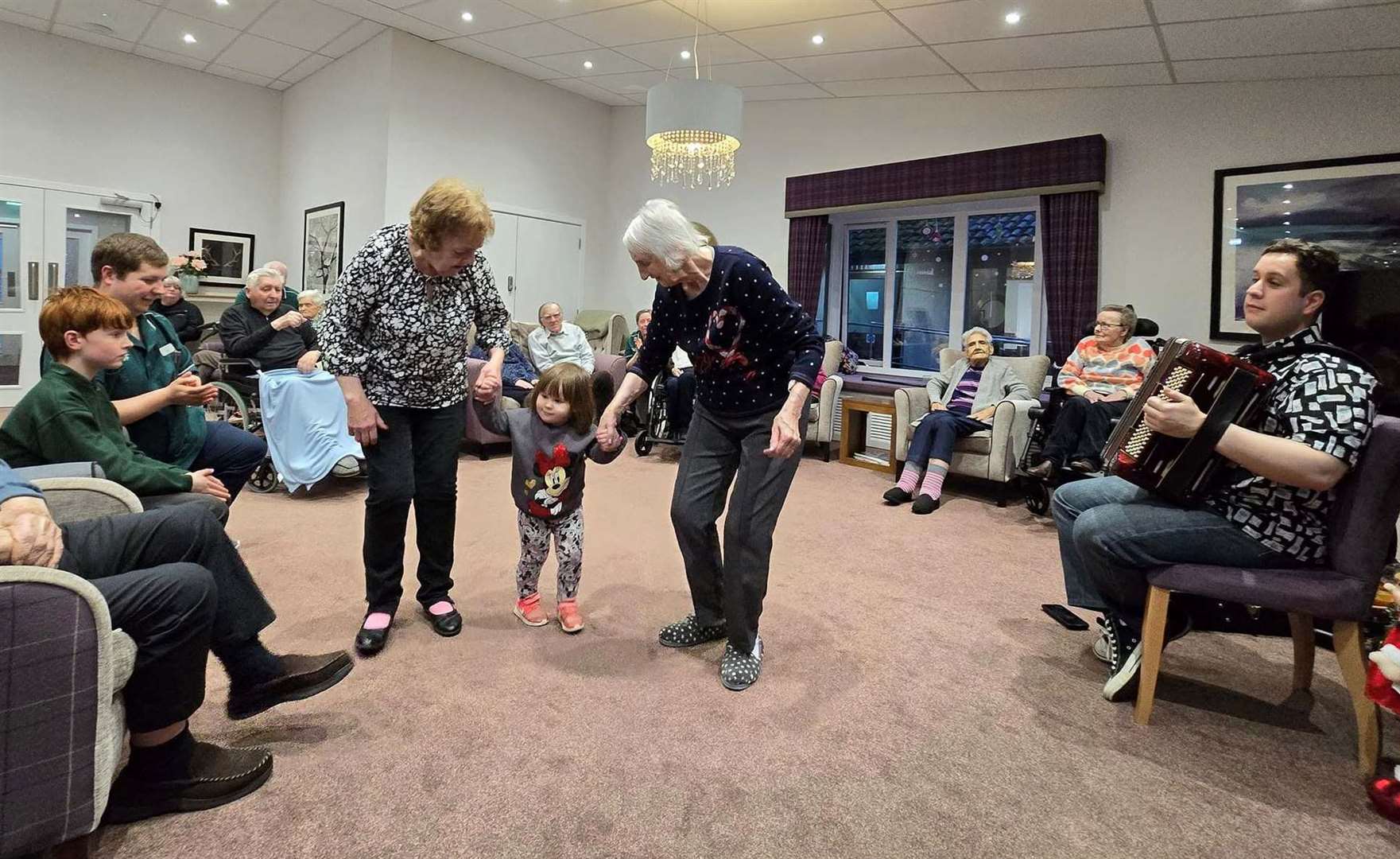 Nancy MacAlpine and Gwen Stuart dance with carer Steph White’s daughter Lorna.