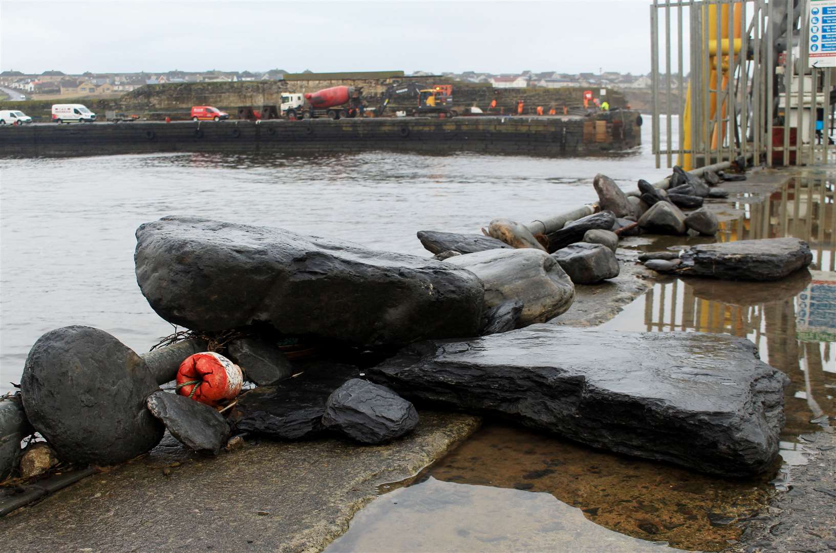 Large rocks thrown up by recent stormy weather, while (in the background) work continues on the emergency stabilisation scheme. Picture: Alan Hendry