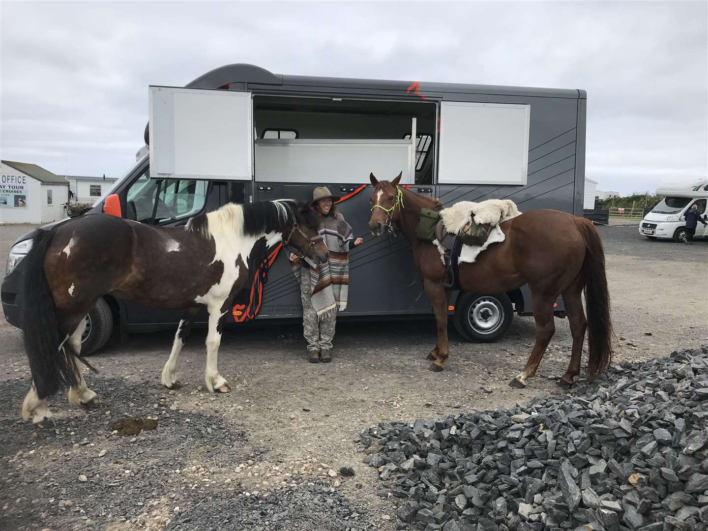 Elsa with her horses Summer (left) and Rosie as she gets ready to set off at John O'Groats. She is wearing a wool Mexican poncho to help keep her warm on her journey.