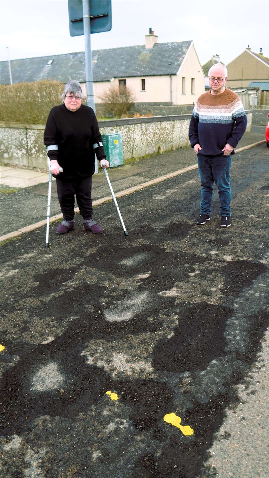 Lynne Hook worries she will stumble in the potholes on the crumbling road surface outside her home in Keiss. Picture: DGS