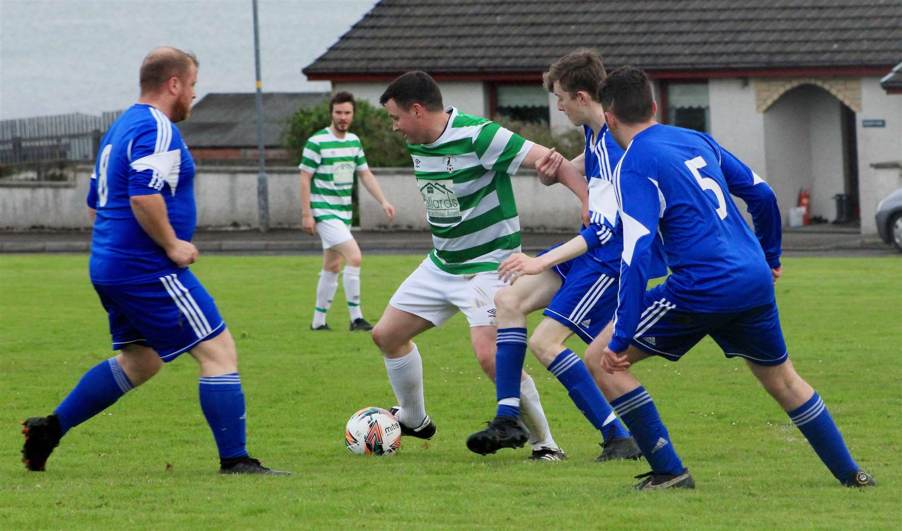Castletown's Michael Smith finds himself surrounded by Keiss opponents.