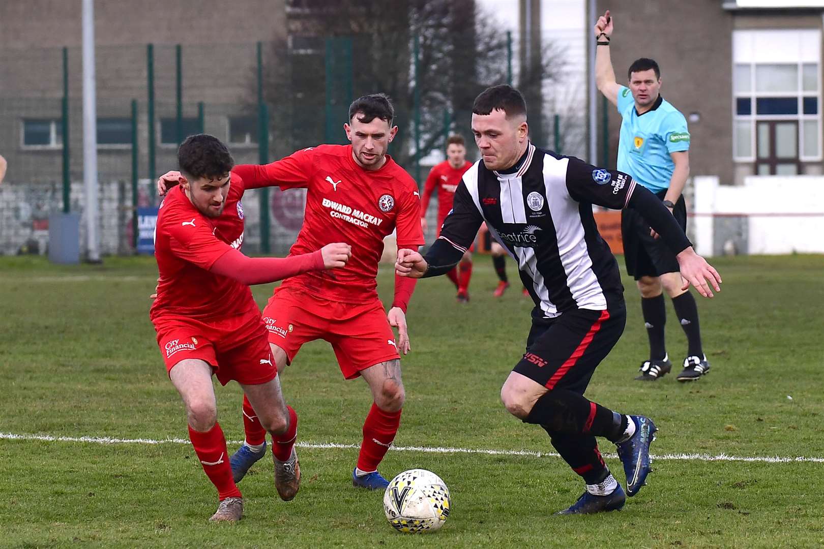 Gordon MacNab takes on Brora duo Tom Kelly and Ali Sutherland in the Dudgeon Park derby. Picture: Mel Roger